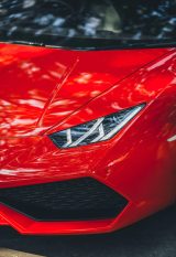 Close-up of a red Lamborghini Huracan parked on a street in New Delhi, India.