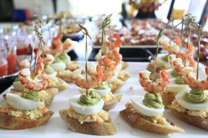 Close-up of gourmet shrimp and avocado canapés on toasted bread, perfect for elegant dining.
