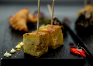Mouth-watering Argentinian tapas on a slate plate with decorative garnish, perfect for food lovers.